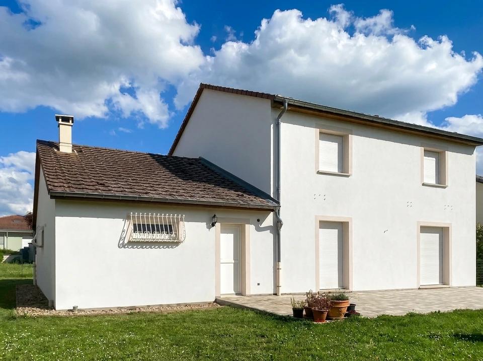Deux peintres en bâtiment travaillent sur échafaudage pour rénover la façade d'une maison