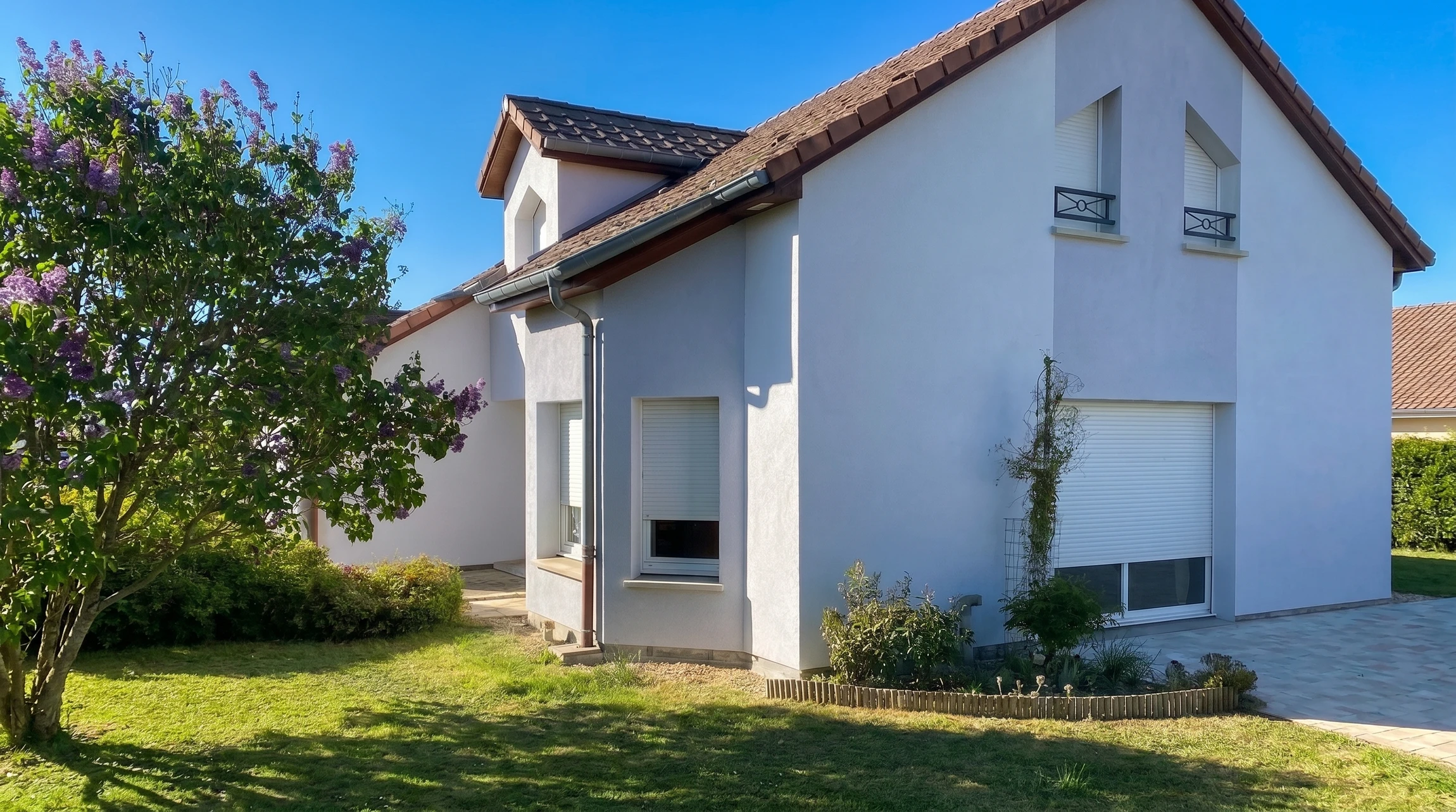 Façade extérieure d'une maison traditionnelle en pierre calcaire avec porte d'entrée verte à panneaux et fenêtre assortie aux volets ouverts